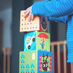 Mains de jeune enfant jouant avec des cubes en bois décorés