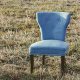 Petit fauteuil bleu capitonné posé dans l'herbe